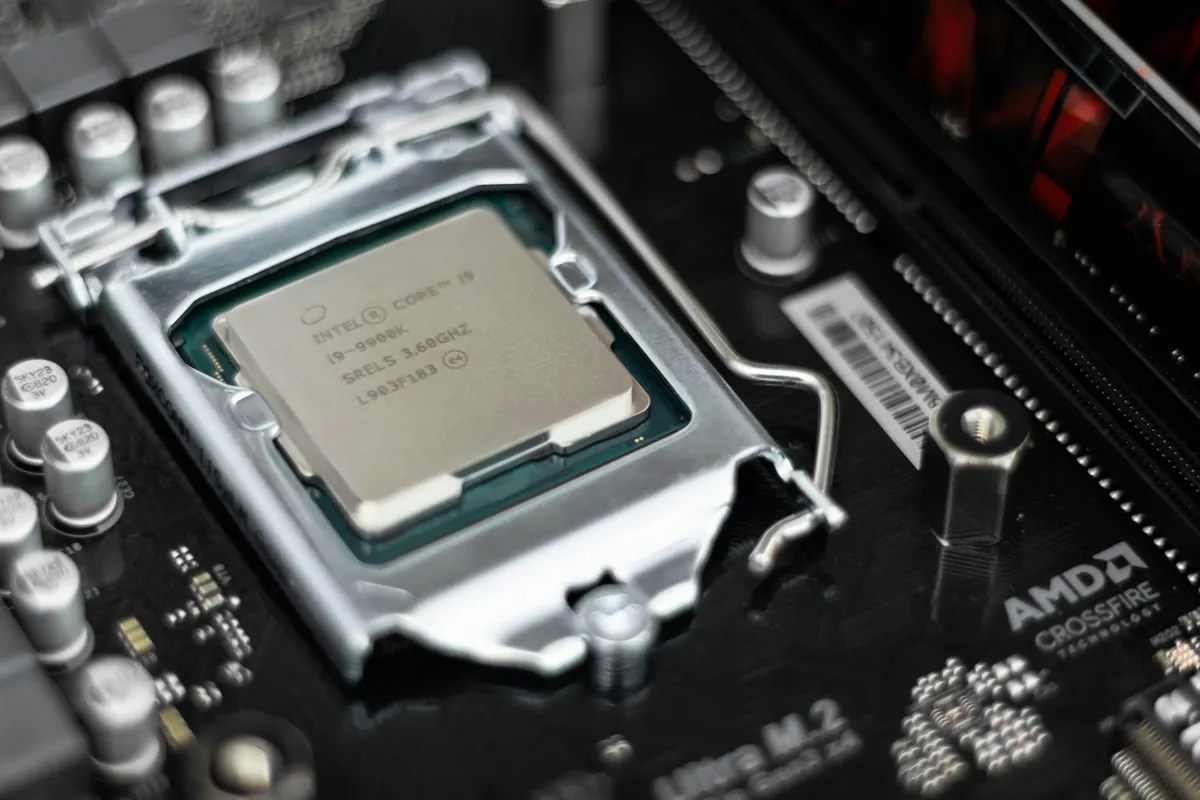 A processor held by its edges, showing the integrated heat spreader